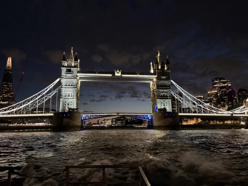 Beleuchtete Tower Bridge bei Nacht vom Boot auf der Themse